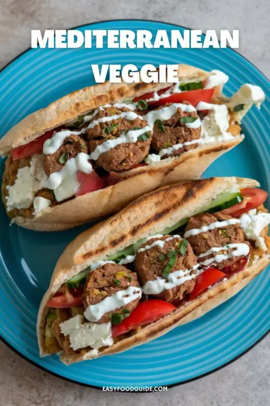 Mediterranean Veggie Sandwich with falafel, hummus, and feta cheese on a blue plate.