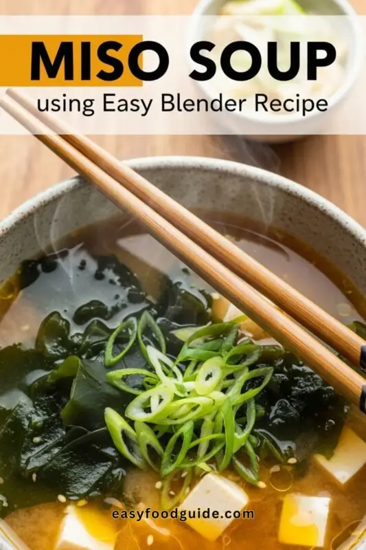 A bowl of miso soup with tofu and seaweed, garnished with green onions, served with chopsticks in soft lighting.