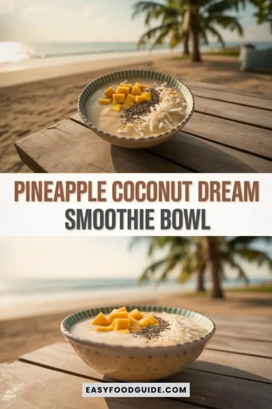 pineapple-coconut-smoothie-bowl-1 A colorful pineapple coconut smoothie bowl topped with pineapple chunks and coconut flakes on a wooden table with palm leaves.