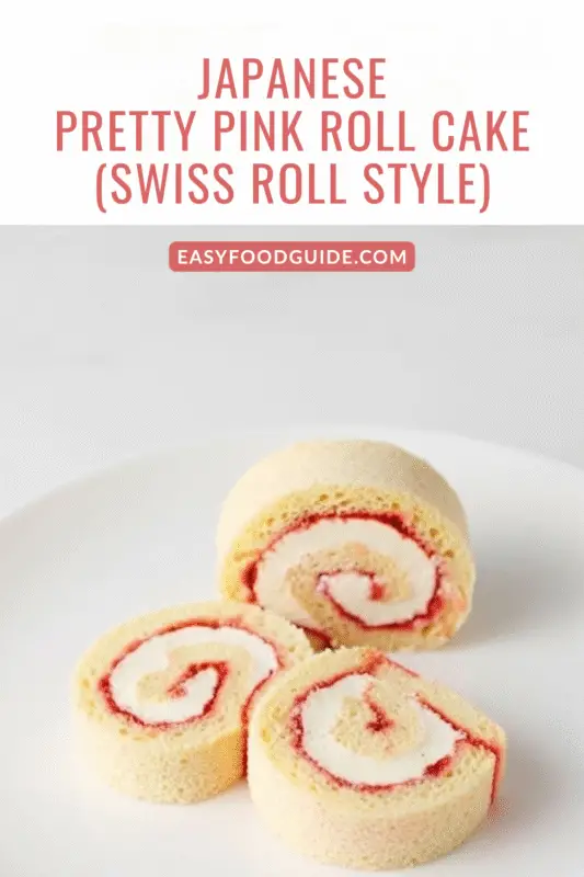 A beautifully sliced Japanese roll cake with a pink swirl on a pastel plate.