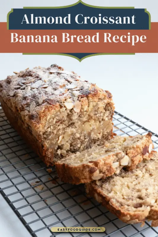 Thick slices of Almond Croissant Banana Bread on a rustic wooden board, showcasing almond frangipane and topped with flaked almonds and icing sugar.