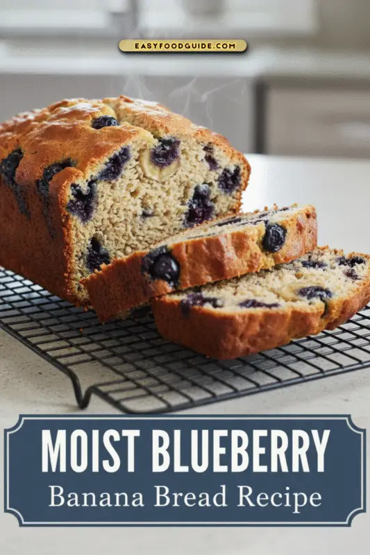 Freshly baked blueberry banana bread loaf on a wooden cutting board with slices stacked.