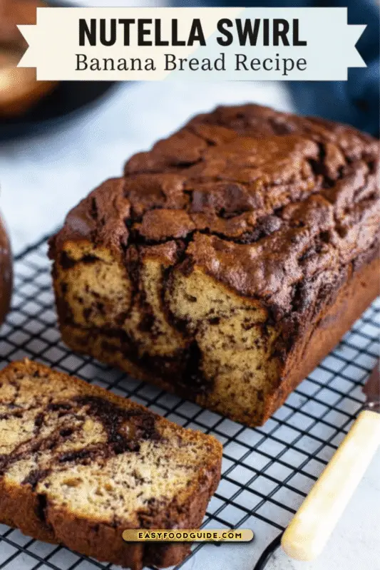 Sliced Nutella Swirl Banana Bread on a wooden board with bananas and Nutella in the background.
