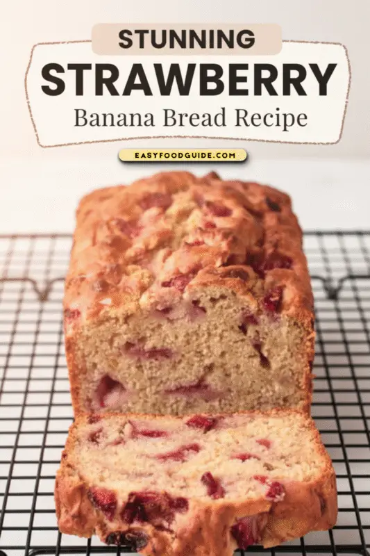 A warm loaf of Strawberry Banana Bread, sliced to reveal a moist interior filled with fresh strawberries.