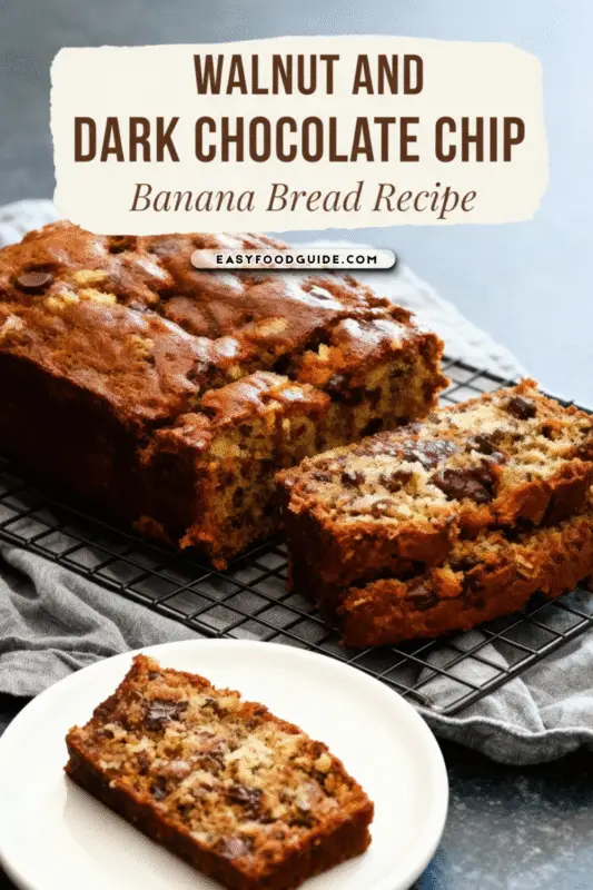 A slice of moist chocolate chip banana bread with walnuts on a wooden cutting board, with steam rising.