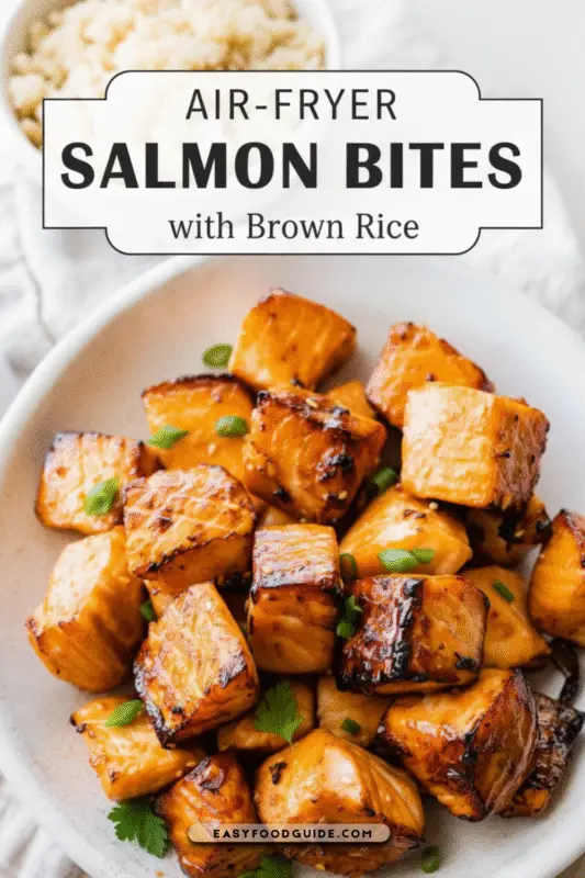 Golden-brown air-fryer salmon bites served with brown rice in a rustic bowl, illuminated by soft natural light.
