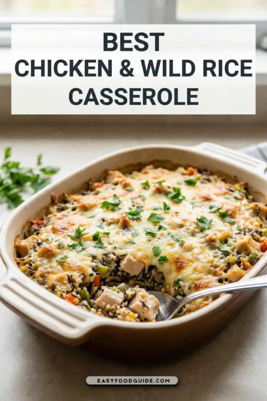 Baked chicken and wild rice casserole with cheese and parsley on a wooden table.
