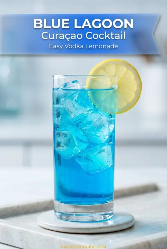 A refreshing Blue Curaçao Lagoon cocktail in a tall glass with ice, garnished with lemon and cherry, set in a tropical background.