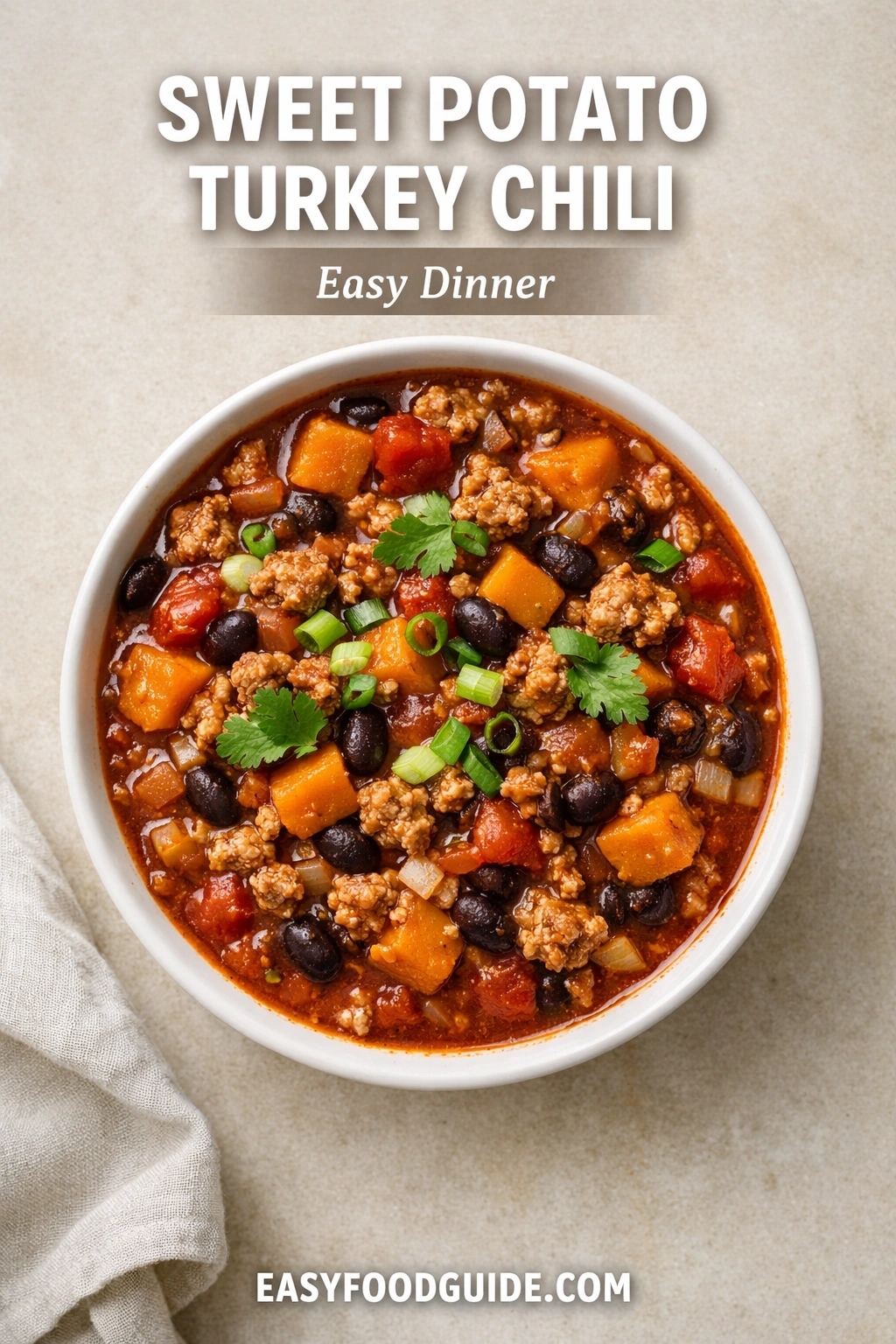 A bowl of sweet potato turkey chili, an easy dinner option. The hearty stew is filled with ground turkey, black beans, and chunks of sweet potato, garnished with cilantro and green onions. Text reads "SWEET POTATO TURKEY CHILI Easy Dinner," and the website "EASYFOODGUIDE.COM" is at the bottom.