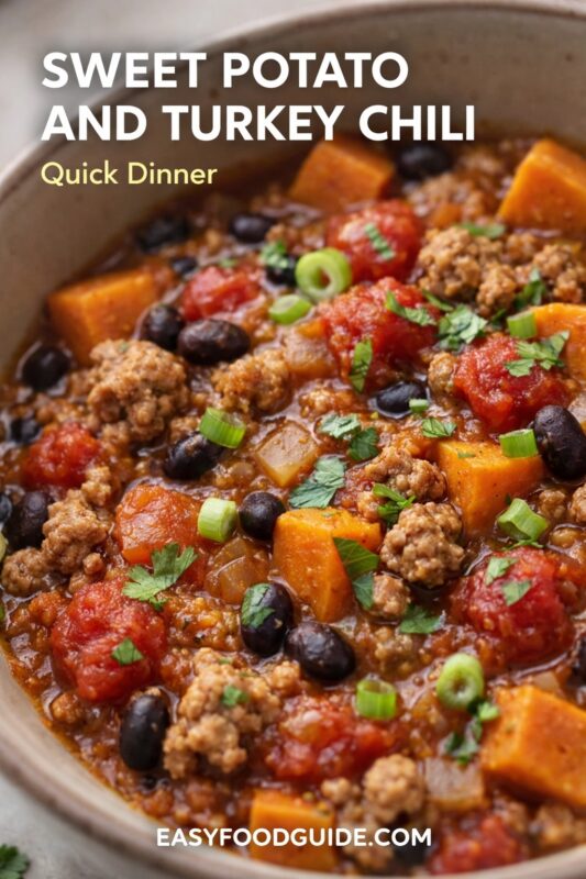 A close-up of sweet potato and turkey chili, a quick dinner option. The hearty bowl is filled with ground turkey, black beans, sweet potatoes, and tomatoes, garnished with fresh herbs. Text reads "SWEET POTATO AND TURKEY CHILI Quick Dinner," and the website "EASYFOODGUIDE.COM" is at the bottom.