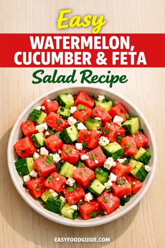 An easy watermelon, cucumber & feta salad recipe, served in a light-colored bowl on a wooden surface. The refreshing salad is made with diced watermelon, cucumber, and crumbled feta cheese, garnished with fresh herbs. Text reads "Easy WATERMELON, CUCUMBER & FETA Salad Recipe," and the website "EASYFOODGUIDE.COM" is at the bottom.