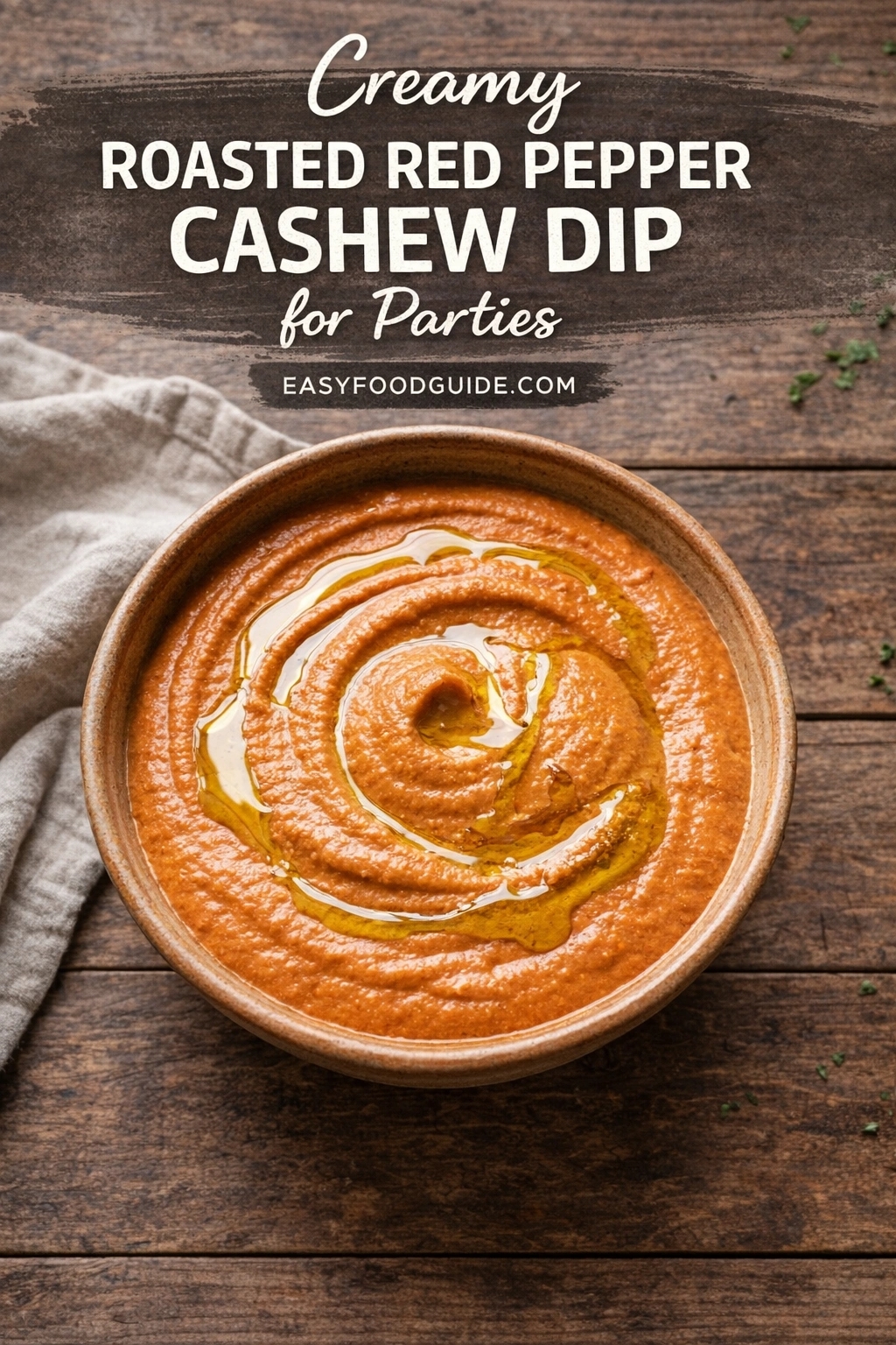 Creamy roasted red pepper cashew dip in a rustic ceramic bowl, swirled with olive oil on top. Set on dark wood table beside a linen napkin; scattered herbs add freshness. Text overlay: “Creamy ROASTED RED PEPPER CASHEW DIP for Parties” + “EASYFOODGUIDE.COM”. Smooth, vibrant orange dip — elegant, vegan-friendly party appetizer.