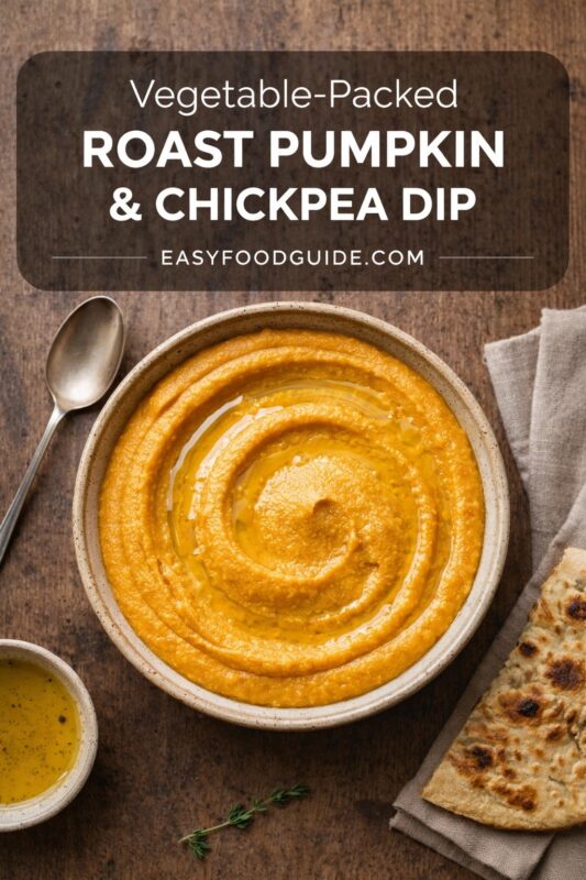 roast-pumpkin-chickpea-dip-4 Top-down view of a rustic ceramic bowl filled with smooth, vibrant orange roast pumpkin & chickpea dip, swirled with olive oil. Beside it: a spoon, small dish of seasoned oil, fresh thyme sprig, and folded flatbread on linen napkin — all arranged on dark wood surface. Text overlay in rounded dark banner reads: “Vegetable-Packed ROAST PUMPKIN & CHICKPEA DIP EASYFOODGUIDE.COM” — white sans-serif font. Warm, earthy styling highlights wholesome, plant-based appeal.