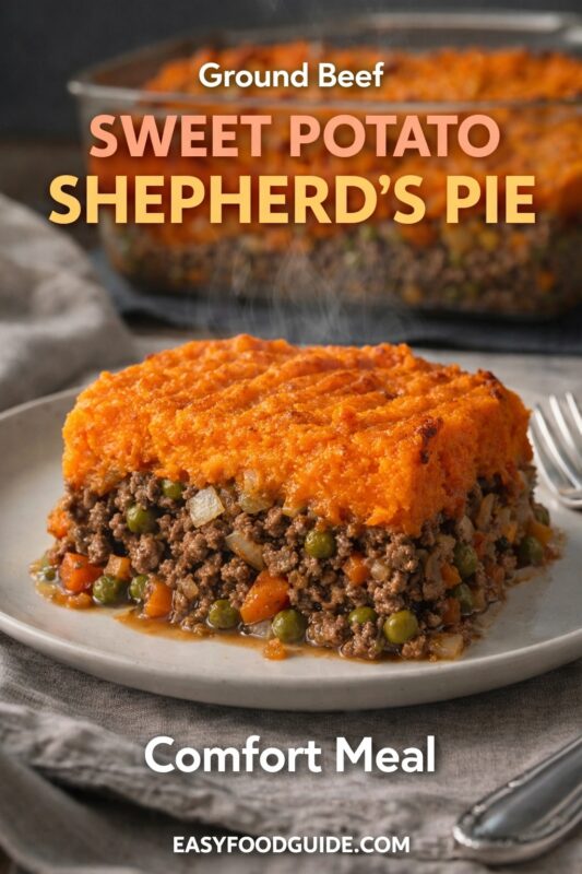 Ground beef sweet potato shepherd’s pie: steaming slice on plate reveals savory meat, peas, carrots under vibrant orange mash. Baking dish in background. Text: “Ground Beef Sweet Potato Shepherd’s Pie – Comfort Meal” + EASYFOODGUIDE.COM. Rustic linen, fork beside — hearty, home-style dinner.
